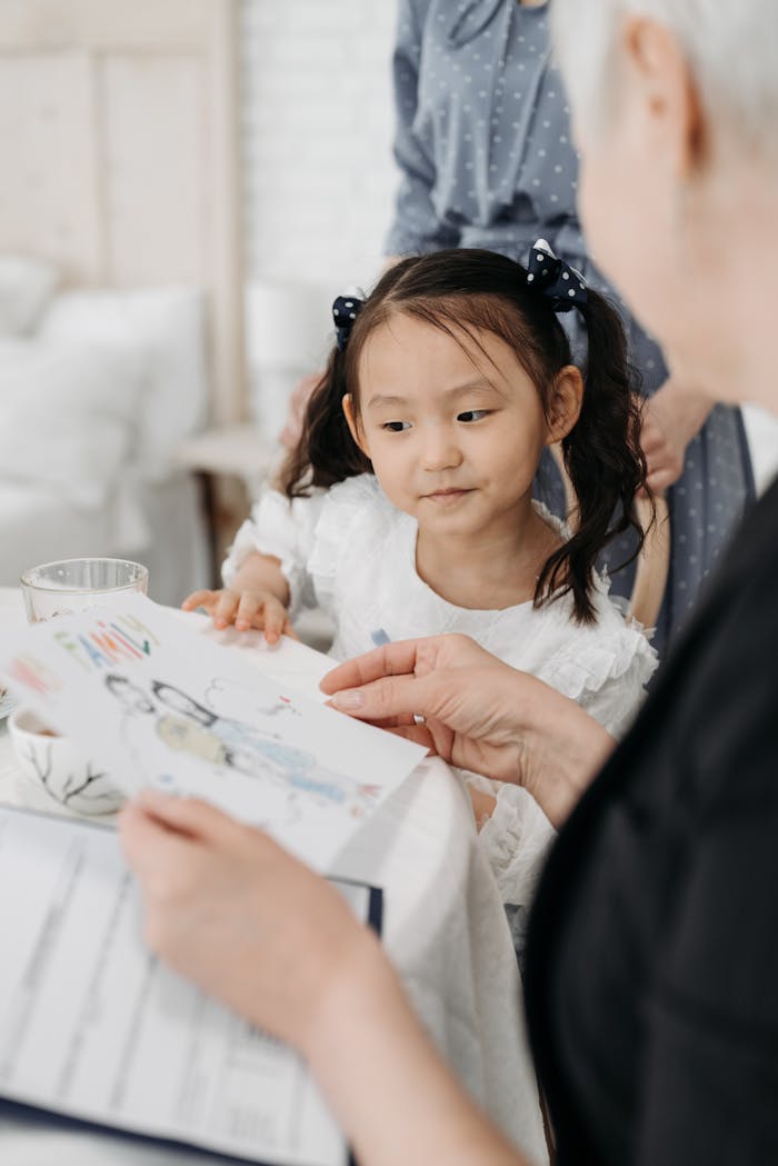 who-we-are A social worker and a child bonding over drawings in a foster care setting.